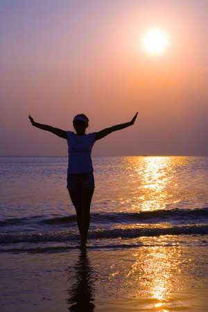 Woman posing along the coastline in sunset の写真素材