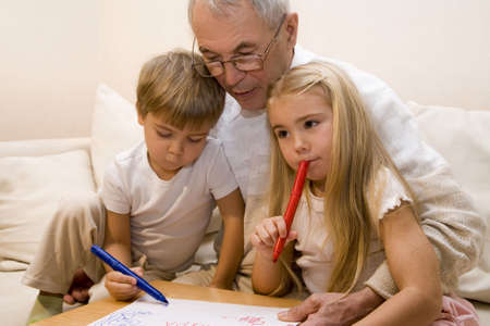 Grandpa is teaching his grandchildren to draw   の写真素材