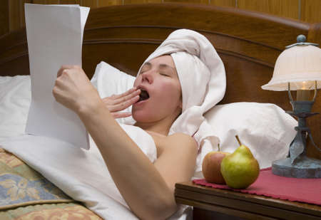 Young woman is reading bedside literature  の写真素材