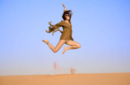 Jumping girl on the sand  の写真素材
