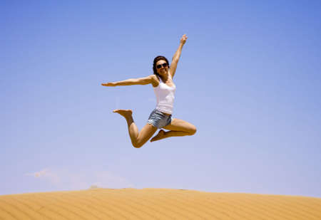 Young girl jump on the sand  の写真素材