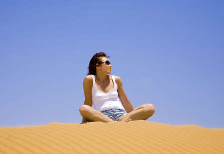 Young woman sitting on the dune  の写真素材