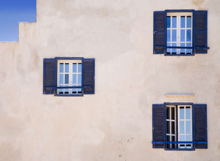 White wall with three blue windows of a colonial style  の写真素材