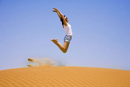 Young girl jump on the sand  の写真素材