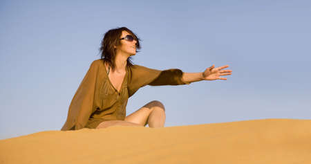 Pretty woman sitting on the dune  の写真素材