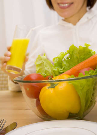 Still life of vegetables with girl drinking orange juice  の写真素材