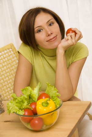Portrait of young woman with tomato in her hand  の写真素材