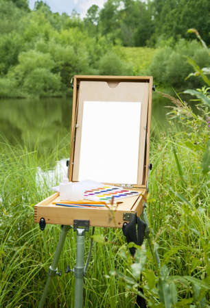Easel, canvas, and brushes. Painting might be used for any substitute picture.  の写真素材
