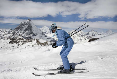 Young woman ski down a mountain slopeの写真素材
