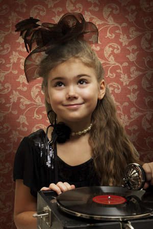 Eight years old girl dressed in retro style with gramophoneの写真素材