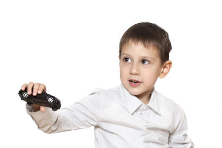 Isolated on white cute boy playing with carの写真素材