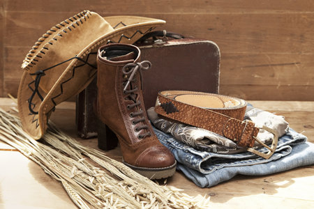 Cowboy hat and accessories against a wood textured background