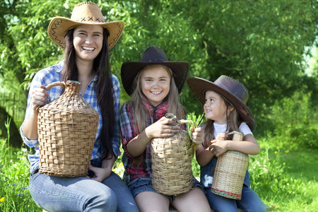 Portrait of three Caucasian girls in cowboy hats in a garden
