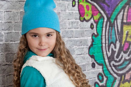 Portrait of teenage girl in front of brick wallの写真素材