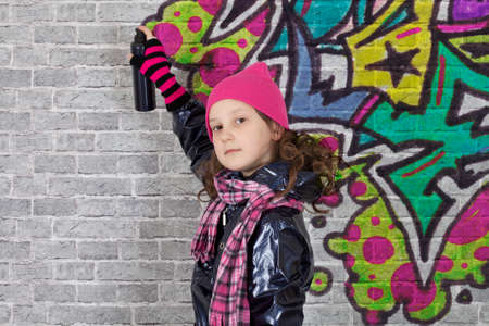 Teenager girl painting a graffiti on a wallの写真素材