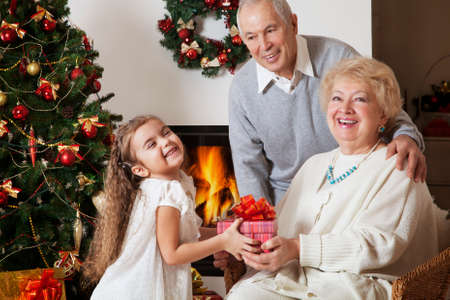 Little girl giving present to her grandma at Christmas, smilingâ¦
の写真素材