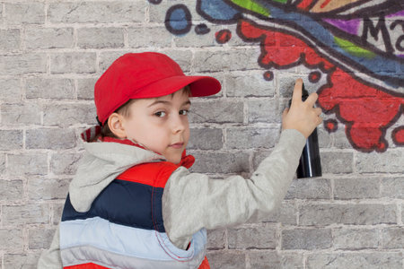 Teenager boy painting a graffiti on a wall
