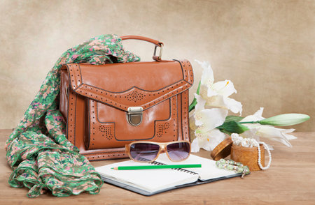 Leather female bag with silk scarf, flowers and accessories