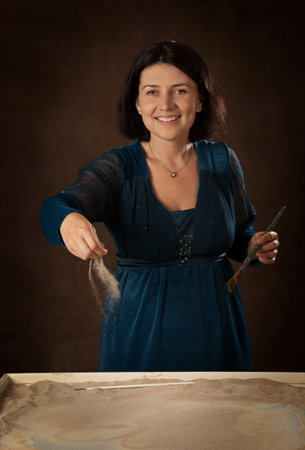 Portrait of a female artist drawing on the sandの写真素材