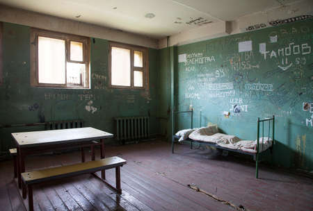 Dark prison cell with dirty walls and metal bad at abandoned Penitentiaryの写真素材