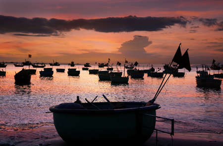 Vietnamese round fishing boat-baskets in the setting sun. Mui Ne, Vietnamの写真素材