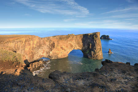 Rocks formation on Dyrholaey cape with black sand beach near  Vik town, Iceland in autumn on sunny dayの写真素材