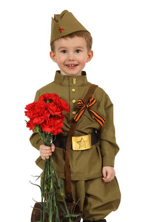 The little boy in the old-fashioned Soviet military uniform with a bouquet of red carnations isolated on white backgroundの写真素材