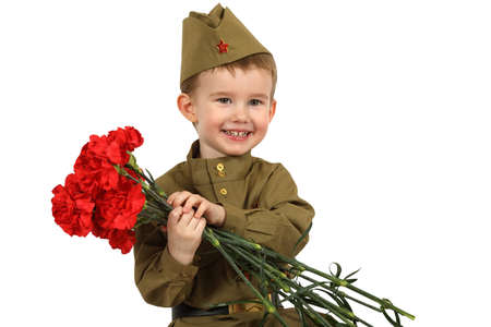 Portrait of little boy dressed in the old-fashioned Soviet military uniform with a bouquet of red carnations isolated on white backgroundの写真素材