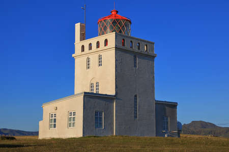 Lighthouse at sunny day against a clear blue sky in Vik town in Southern Icelandの写真素材