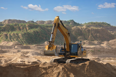 Yellow  excavator working digging in sand quarry