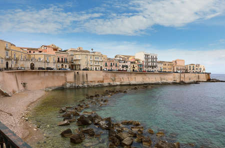 The coastal line of the central part of the Sicilian town of Syracuse in the background of the blue sky. Syracuse is a historicÂ cityÂ on the island ofÂ Sicily, theÂ capitalÂ of the ItalianÂ province of Syracuseの写真素材