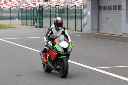 Motorcyclist on a racing motorcycle back from the race track to the pitsの写真素材