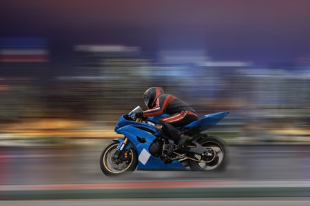 Motorcycle rider racing at high speed with motion blur on a colorful background
