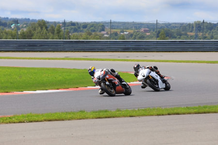 Two riders on motorcycles riding on the race track at high speed