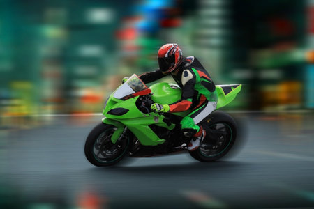 Motorcycle rider in helmet and gear racing at high speed on the nighttime background with motion...