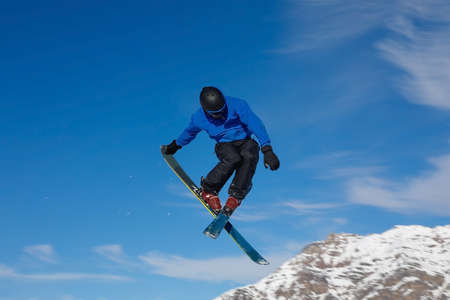 Freestyle ski jumper with crossed skis in air with blue sky background
の写真素材