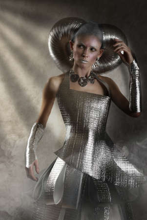 Beautiful model girl in incredible space clothes and futuristic makeup on a black background in studioの写真素材