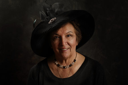 Portrait of an old lady in the Victorian style in the studio on an artistic background
