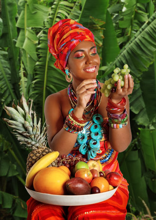 Portrait of young attractive African American woman with artistic make-up and a tray of fruit on her...