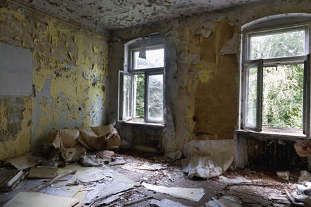 Interior of a living room with two windows of an old abandoned houseの写真素材