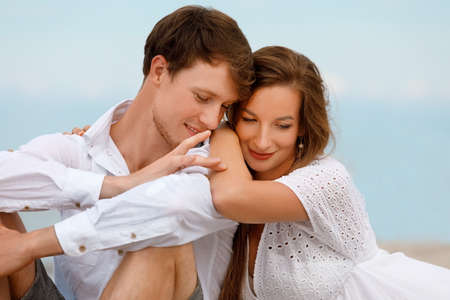 Portrait of a cute couple of young lovers resting on the beach on a sunny summer dayの写真素材