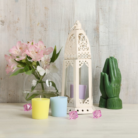 Still life with beautiful hand made candles and fresh flowers on an artistic wooden background