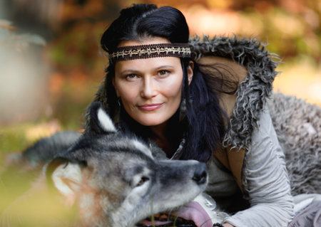 Portrait of a nice woman with an Alaskan Malamute dog in the autumn forest against the background of...