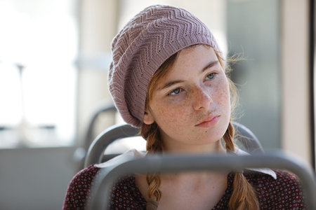 Portrait of a freckled teenage girl with pigtails dressed in retro style clothes in a wagon of a...