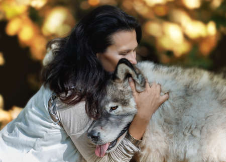 Forest dweller young woman hugs her dog in the autumn forestの写真素材