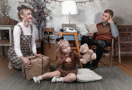 Young family rests in the evening at home in a festive decorated room waiting for Christmasの写真素材