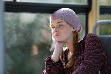 Portrait of a cute freckled girl with pigtails dressed in retro style clothes in the city tram. Transportation, travel and lifestyle conceptの写真素材