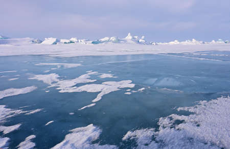 Frozen icy surface of the Baikal lake near Olkhon Island, Russia. Clear winter weatherの写真素材