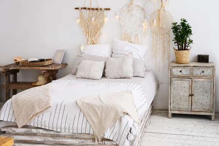 Modern comfortable bedroom with a large bed and a bedside table in bright colorsの写真素材