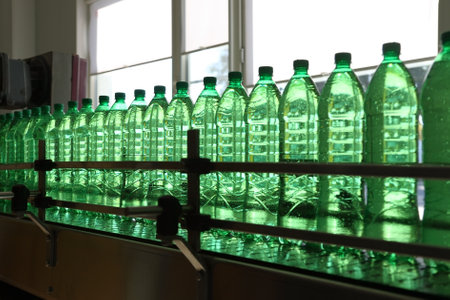 Conveyer line with plastic bottles filled with mineral water at the plant for the manufacture of beveragesの写真素材